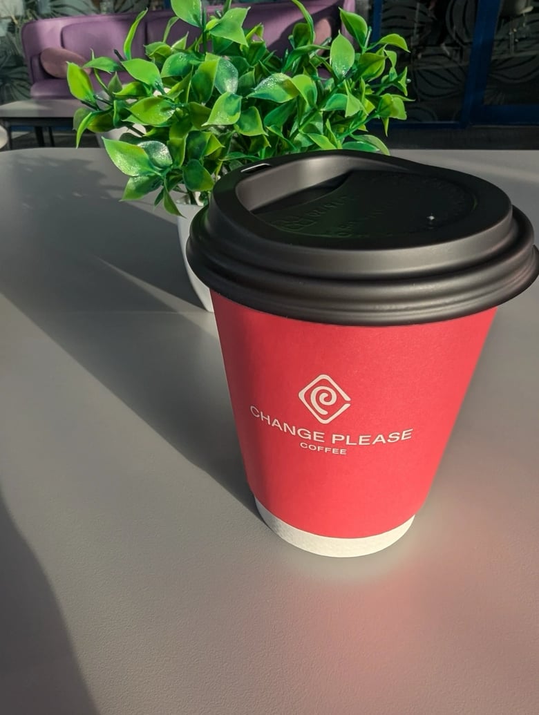 Red takeaway coffee cup on greay table.